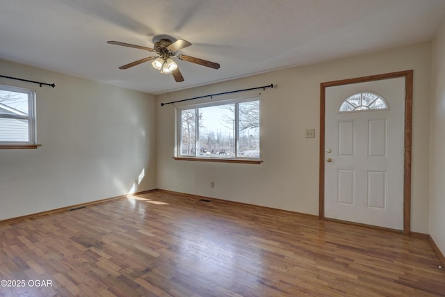 foyer entrance with hardwood / wood-style flooring, a wealth of natural light, and ceiling fan