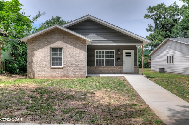 view of front facade featuring covered porch, a front lawn, and central air condition unit