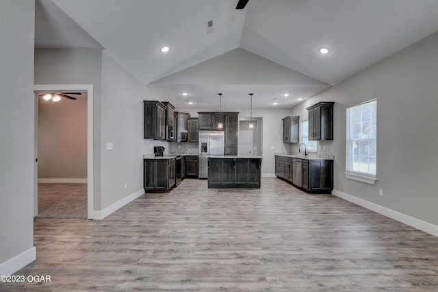 kitchen with a kitchen island, pendant lighting, ceiling fan, stainless steel appliances, and dark brown cabinets