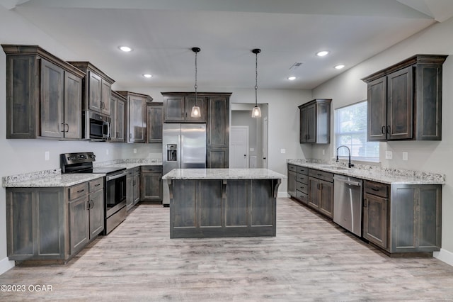 kitchen with sink, a center island, dark brown cabinets, hanging light fixtures, and stainless steel appliances