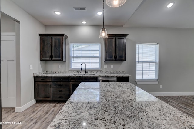 kitchen featuring light hardwood / wood-style flooring, sink, dark brown cabinets, and light stone countertops