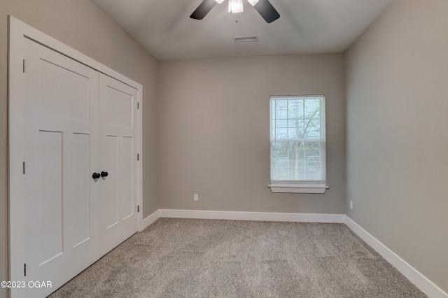 spare room featuring light carpet and ceiling fan