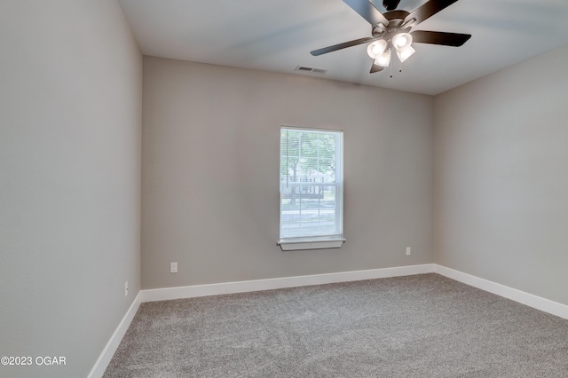 carpeted spare room with ceiling fan