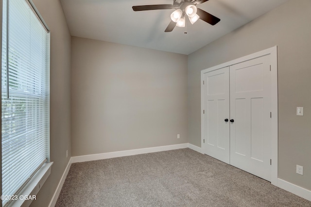 unfurnished bedroom with ceiling fan, a closet, and carpet