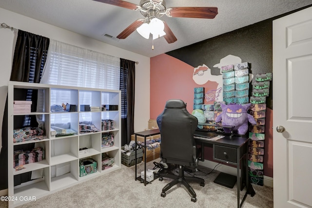 carpeted home office with a textured ceiling and ceiling fan