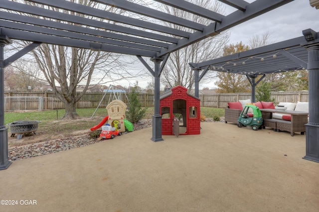 view of play area featuring a pergola, an outdoor living space with a fire pit, and a patio