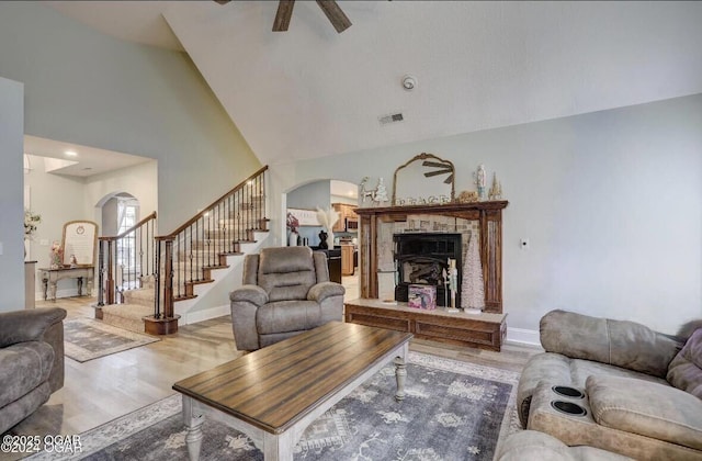 living room with ceiling fan, wood-type flooring, and high vaulted ceiling