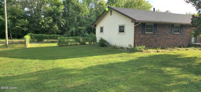 view of side of home with a yard