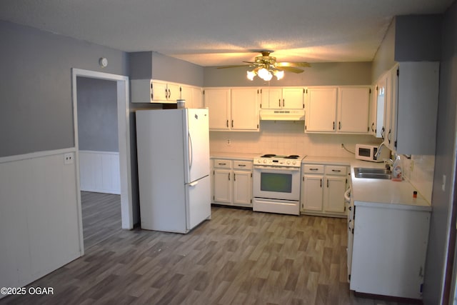 kitchen with sink, white appliances, white cabinetry, a textured ceiling, and light wood-type flooring