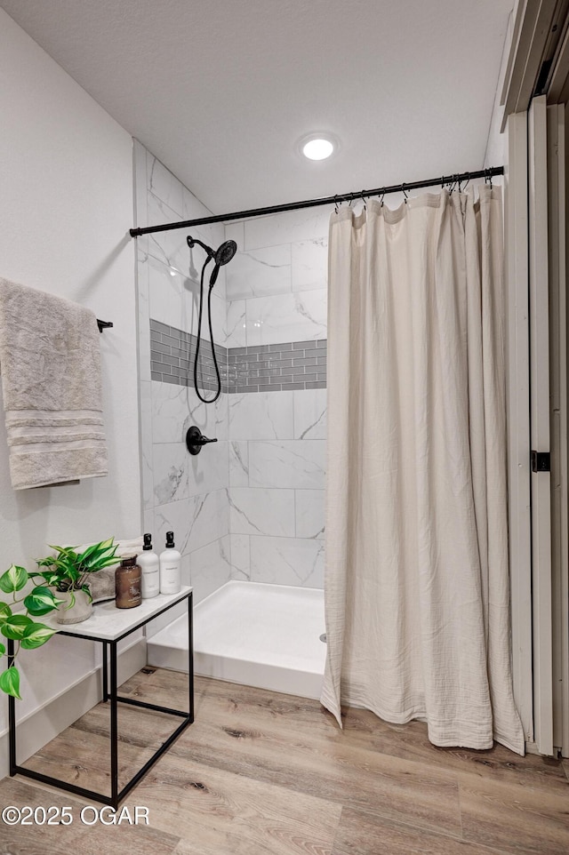 bathroom featuring walk in shower and wood-type flooring