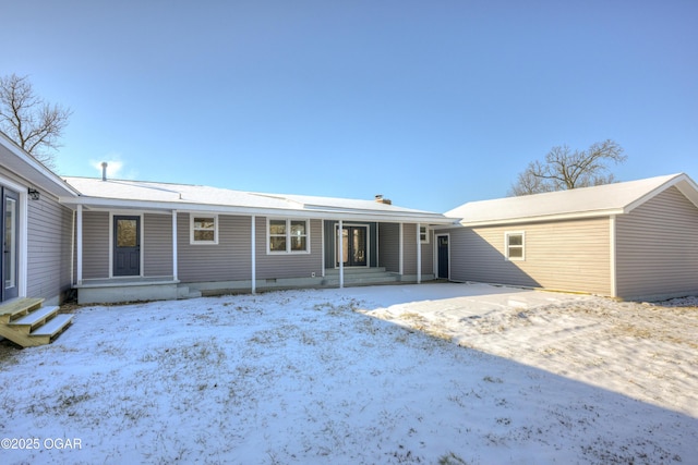 snow covered rear of property with covered porch