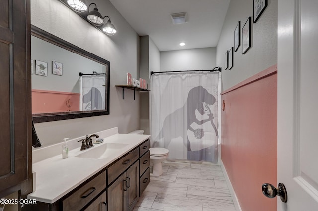 bathroom featuring toilet, vanity, and a shower with curtain