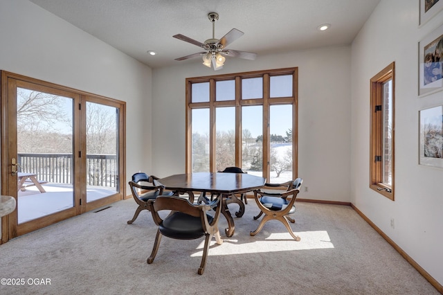 dining area featuring plenty of natural light, light colored carpet, and ceiling fan