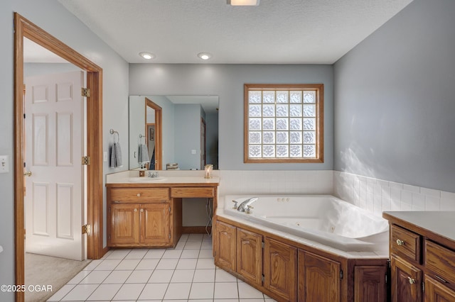 bathroom with tile patterned floors, vanity, a textured ceiling, and a washtub