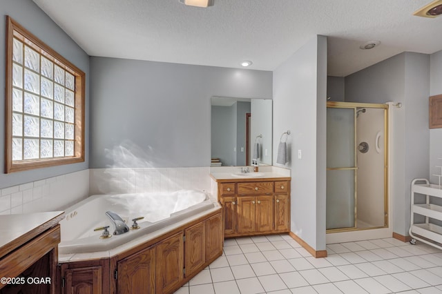 bathroom featuring tile patterned flooring, vanity, shower with separate bathtub, and a textured ceiling