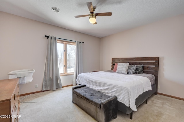 carpeted bedroom with ceiling fan and a textured ceiling