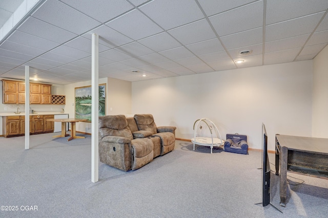 carpeted living room featuring a drop ceiling