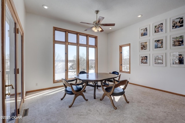 dining space featuring a textured ceiling, carpet floors, and ceiling fan