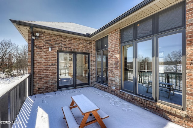 snow covered patio featuring a balcony