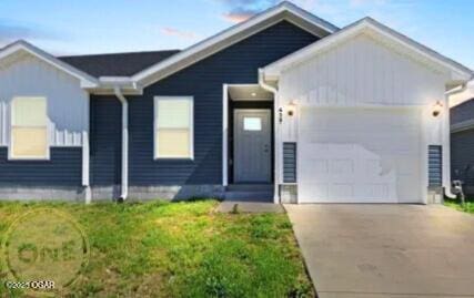 view of front of home featuring driveway, an attached garage, and a front yard