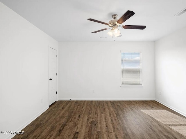 empty room featuring a ceiling fan, baseboards, visible vents, and dark wood-type flooring