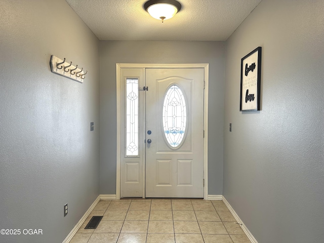 tiled foyer with a textured ceiling