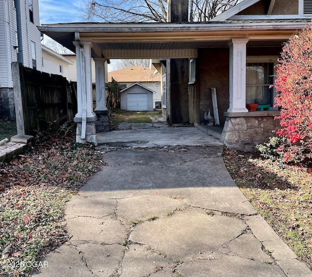 view of parking / parking lot featuring a carport, fence, and driveway