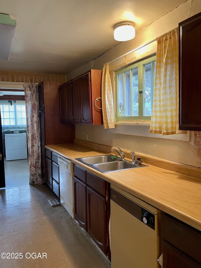 kitchen with dishwasher, washer / dryer, light countertops, and a sink