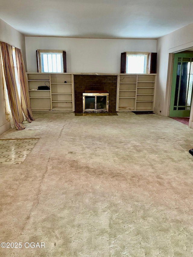 unfurnished living room with a fireplace, light colored carpet, and a wealth of natural light