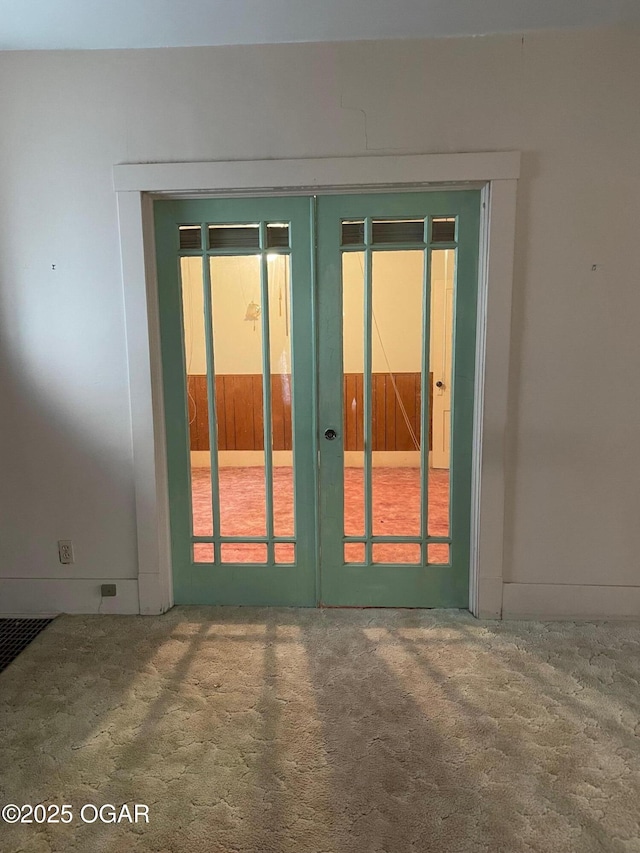 doorway to outside featuring french doors and carpet