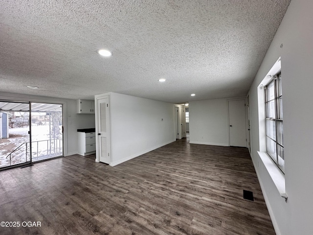 unfurnished living room featuring dark hardwood / wood-style floors and a textured ceiling