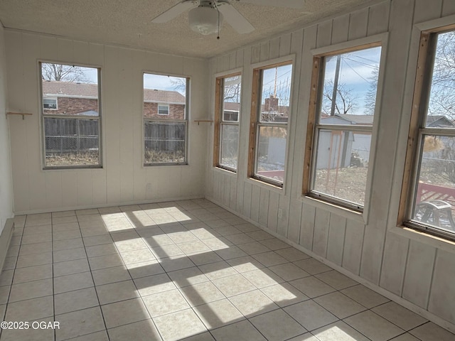 unfurnished sunroom with ceiling fan