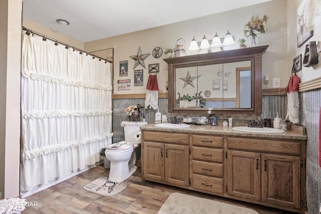 bathroom featuring hardwood / wood-style flooring, toilet, and vanity