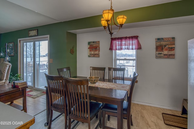 dining space featuring light hardwood / wood-style floors and a chandelier