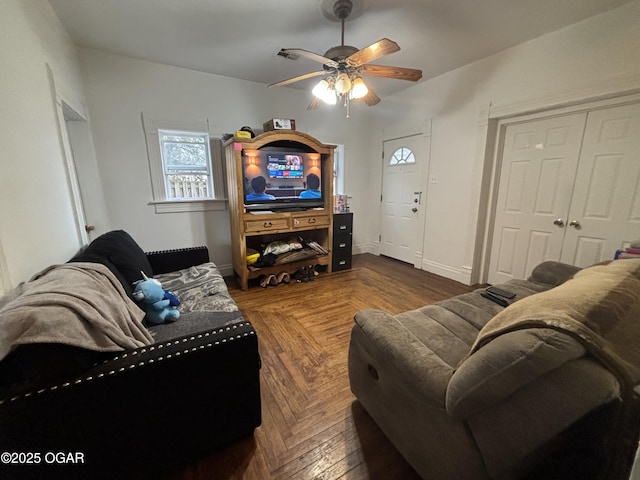 living area featuring baseboards and a ceiling fan