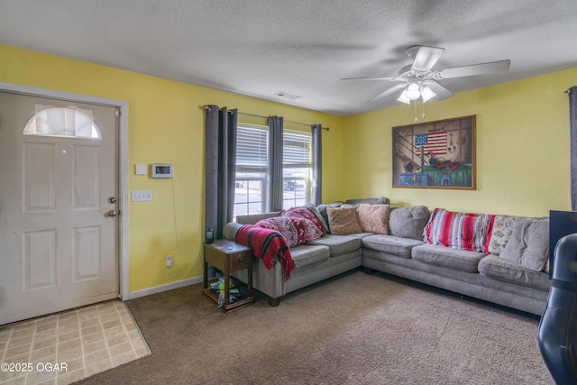 carpeted living room featuring a textured ceiling, ceiling fan, visible vents, and baseboards