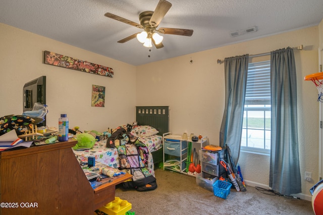 bedroom with a textured ceiling, ceiling fan, carpet, and visible vents