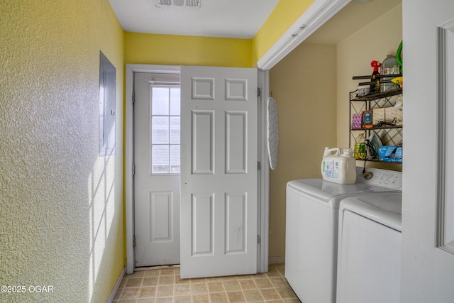 clothes washing area with a textured wall, laundry area, visible vents, independent washer and dryer, and electric panel