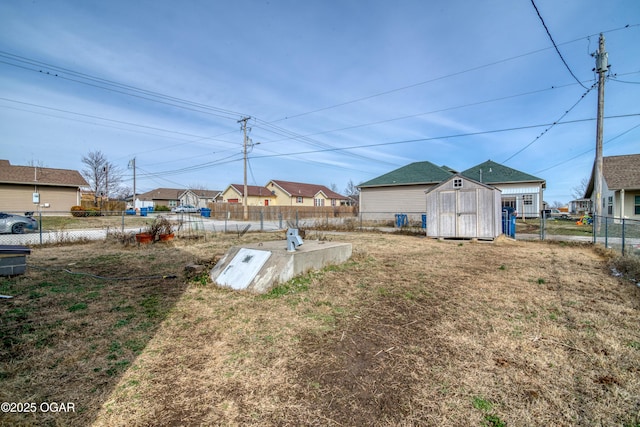 entry to storm shelter featuring a storage shed, a fenced backyard, a residential view, and an outdoor structure