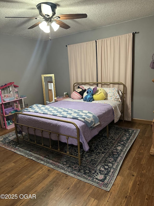 bedroom featuring a textured ceiling, dark wood finished floors, a ceiling fan, and baseboards