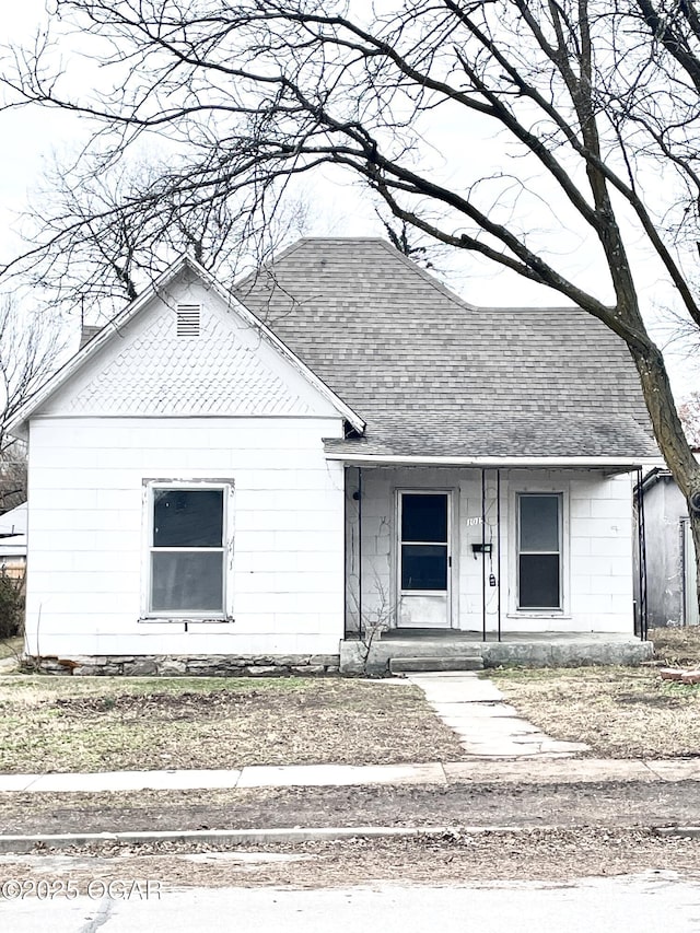 view of front facade featuring covered porch and roof with shingles