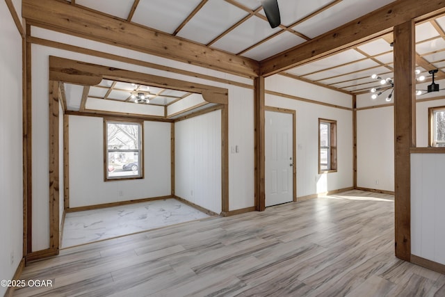 spare room with wood finished floors, baseboards, and an inviting chandelier