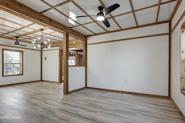 empty room featuring ceiling fan with notable chandelier and wood finished floors