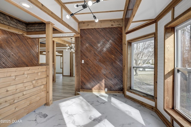 unfurnished room featuring marble finish floor and wooden walls