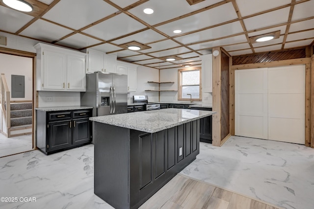 kitchen featuring stainless steel appliances, a kitchen island, white cabinets, marble finish floor, and electric panel