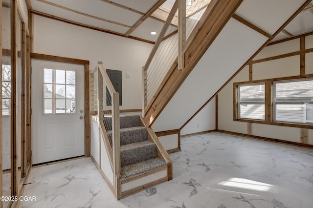 foyer with stairs, marble finish floor, and a healthy amount of sunlight