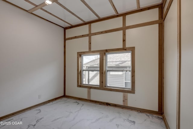 unfurnished room featuring marble finish floor and baseboards