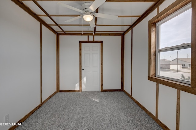 spare room featuring a ceiling fan, light colored carpet, and baseboards