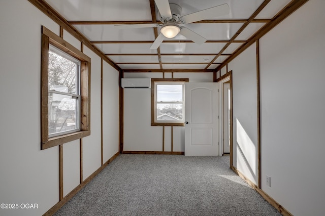 spare room featuring coffered ceiling, carpet, a healthy amount of sunlight, and a wall unit AC