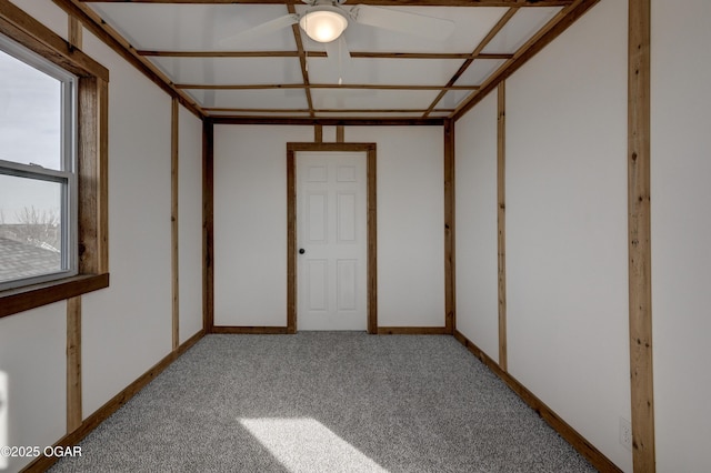 empty room featuring carpet and baseboards